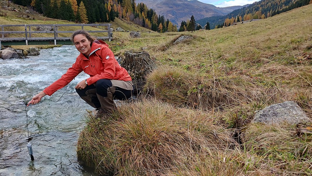 SLF-Hydrologin Amber van Hamel hält einen Sensor in den Dischmabach bei Davos. (Foto: Amber van Hamel / SLF) 