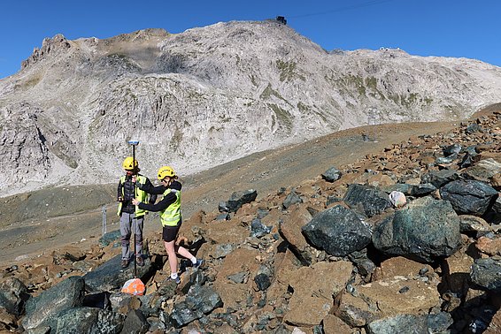 Eine Helferin und ein Helfer bestimmen per GPS die Endposition der Betonklötze. (Foto: Jochen Bettzieche / SLF)